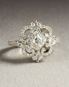 an image of a ring with diamonds on it's sides and the center surrounded by smaller stones