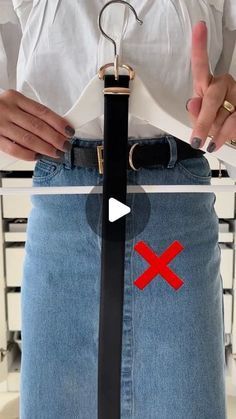 a woman is holding a pair of scissors in her jeans and pointing at the belt