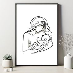 a black and white drawing of a woman holding a baby