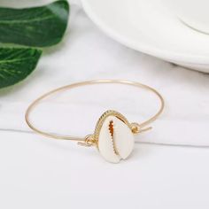 Width Of Bracelet Is 2.5” Gold Tone Alloy Shell Charm Unhooks To Open Boho Bracelet Bangle Cuff Shell Beach Vacation Jewelry Gold Charm Sea Shell Cowrie Elegant Metal Bracelets For Beach, Elegant Gold Bracelets For Vacation, Gold Metal Charm Bracelet For Beach, Adjustable Metal Bracelet For Vacation, Adjustable Metal Bracelets For Vacation, Beach Bangle Bracelets In Metal, Metal Bangle Bracelets For Beach, Metal Oyster Bracelet For Beach, Elegant White Bracelets For Vacation