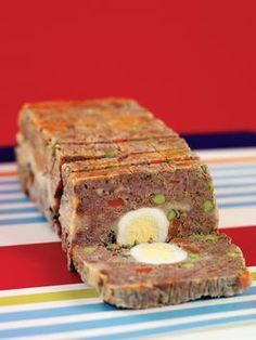 a piece of meatloaf with an egg in the center on a striped plate