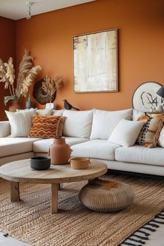 a living room with orange walls and white furniture in the center, including a large sectional couch