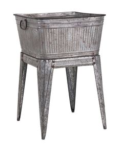 an old metal planter with legs and handles on the bottom, sitting in front of a white background