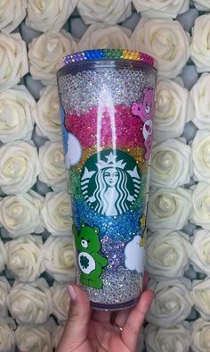 the starbucks cup is decorated with glitter and sesame characters, as well as white roses