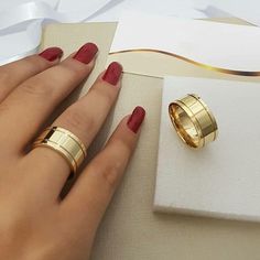 a woman's hand with two gold wedding rings on top of a white napkin