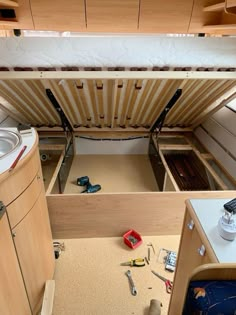 the inside of a storage compartment with tools and other items on the floor next to it