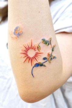 a woman with a tattoo on her arm that has flowers and butterflies painted on it