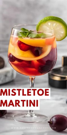 a glass filled with fruit and garnish on top of a white marble counter