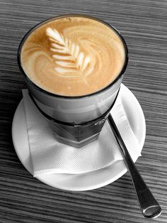 a cappuccino on a saucer with a spoon