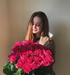 a woman holding a bouquet of pink flowers