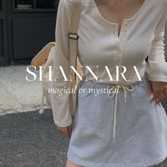 a woman is walking down the street with her hand in her pocket and wearing a white shirt dress