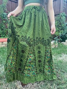 Introducing our Pari Vintage Vibe Green Embroidery Maxi Skirt, perfect for embracing those boho hippie vibes! This stunning skirt features a pleated border that adds a touch of elegance, while the maxi length offers a chic and comfortable fit. Crafted with fairycore fashion in mind, this skirt is ideal for creating enchanting cottage-core looks. Whether you're strolling along sandy shores or exploring hideaways, this skirt will ensure you're dressed to impress. Its flowing silhouette captures the essence of fairycore aesthetics, evoking a sense of whimsy and magic.  Designed for the boho fashionista in you, it is versatile and easy to style. Pair it with a cropped top and woven sandals for a carefree bohemian look, or opt for a lace blouse and floppy hat for a more sophisticated beach ense Maxi Skirt Aesthetic, Aesthetic Whimsical, Vibe Green, Fairy Vibe, Fairycore Fashion, Hippie Rock, Cottage Core Fairy, Skirt Aesthetic, Embroidery Skirt