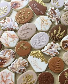 cookies decorated with different types of leaves and designs on top of each other, sitting on a table