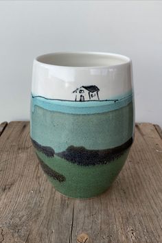 a white and blue bowl sitting on top of a wooden table