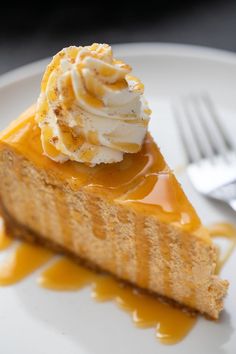 a slice of cheesecake with whipped cream and caramel sauce on a white plate