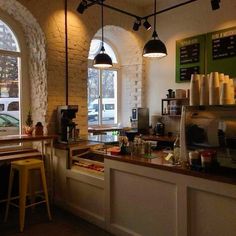 the interior of a coffee shop with tables and stools