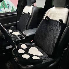 the interior of a car with black and white cat paw print seat covers on it