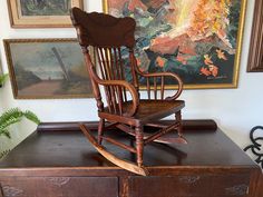 a rocking chair sitting on top of a wooden dresser