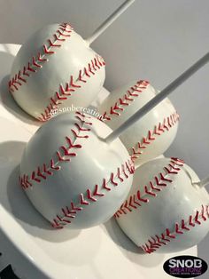 three baseballs are sitting on top of a white plate with red stitching around them