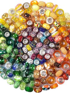 many different colored glass beads arranged in a circle on top of each other, with one bead at the center