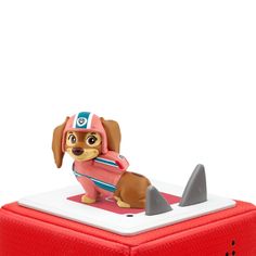 a small toy dog is on top of a red box