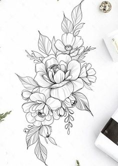 a drawing of flowers and leaves on a white paper next to some other things in the background