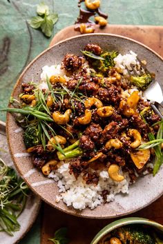 a bowl filled with rice, broccoli and cashews