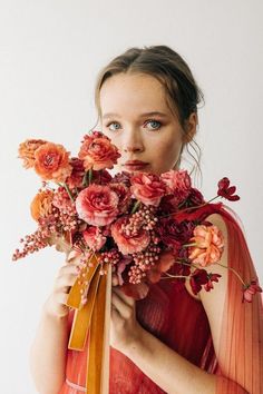 a woman holding a bouquet of flowers in front of her face