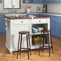 a kitchen with blue cabinets and two stools