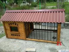 a small wooden dog house with a red roof and metal bars on the top floor