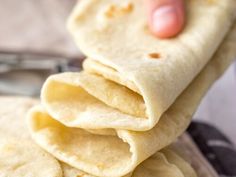 a person is holding some tortillas in their hand