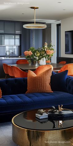 a living room filled with blue couches and orange pillows