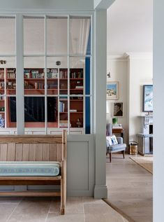 a wooden bench sitting next to a living room filled with furniture and bookshelves