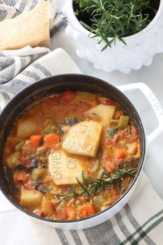 a pot filled with stew and tofu on top of a table