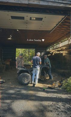 three men standing in front of a truck under a wooden structure with the words slow sunday written on it