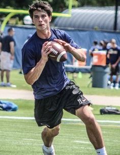 a man holding a football on top of a field