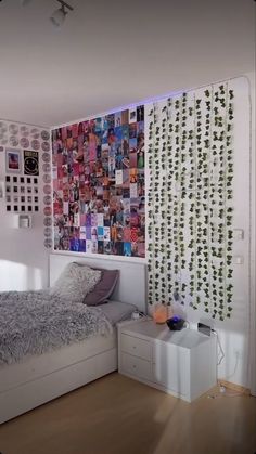 a bed room with a neatly made bed next to a wall covered in pictures and plants