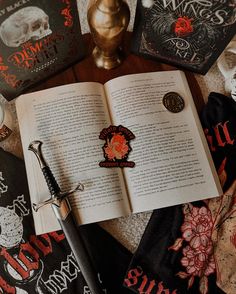 an open book sitting on top of a table next to two other books and a pen