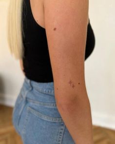 a woman with a small star tattoo on her left arm and right arm behind her back