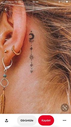 the back of a woman's ear with two small tattoos on it