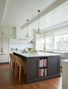 a large kitchen with an island in the middle and lots of bookshelves on it