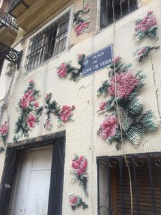 a building that has flowers on the side of it