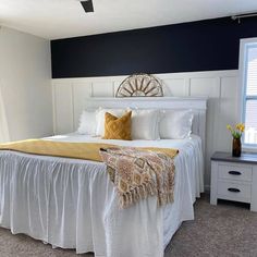 a white bed sitting in a bedroom next to a window