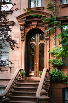 an entrance to a building with stairs and potted plants