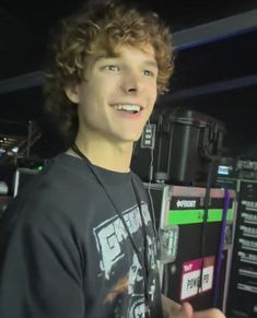 a young man is smiling while standing in front of sound equipment