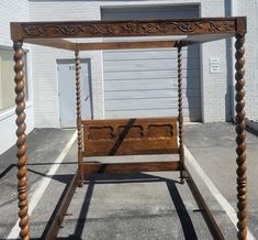 a wooden bed frame sitting in the middle of an empty parking lot next to a building