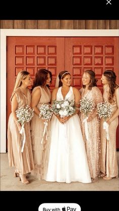 a group of women standing next to each other in front of a red door holding bouquets