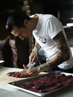 a man in white shirt preparing food on top of a counter