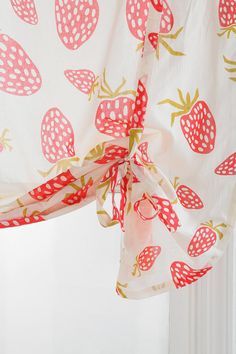 a curtain with strawberry print hanging from it's side