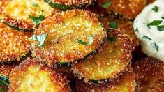 some fried food is sitting on a plate with sour cream and herbs next to it